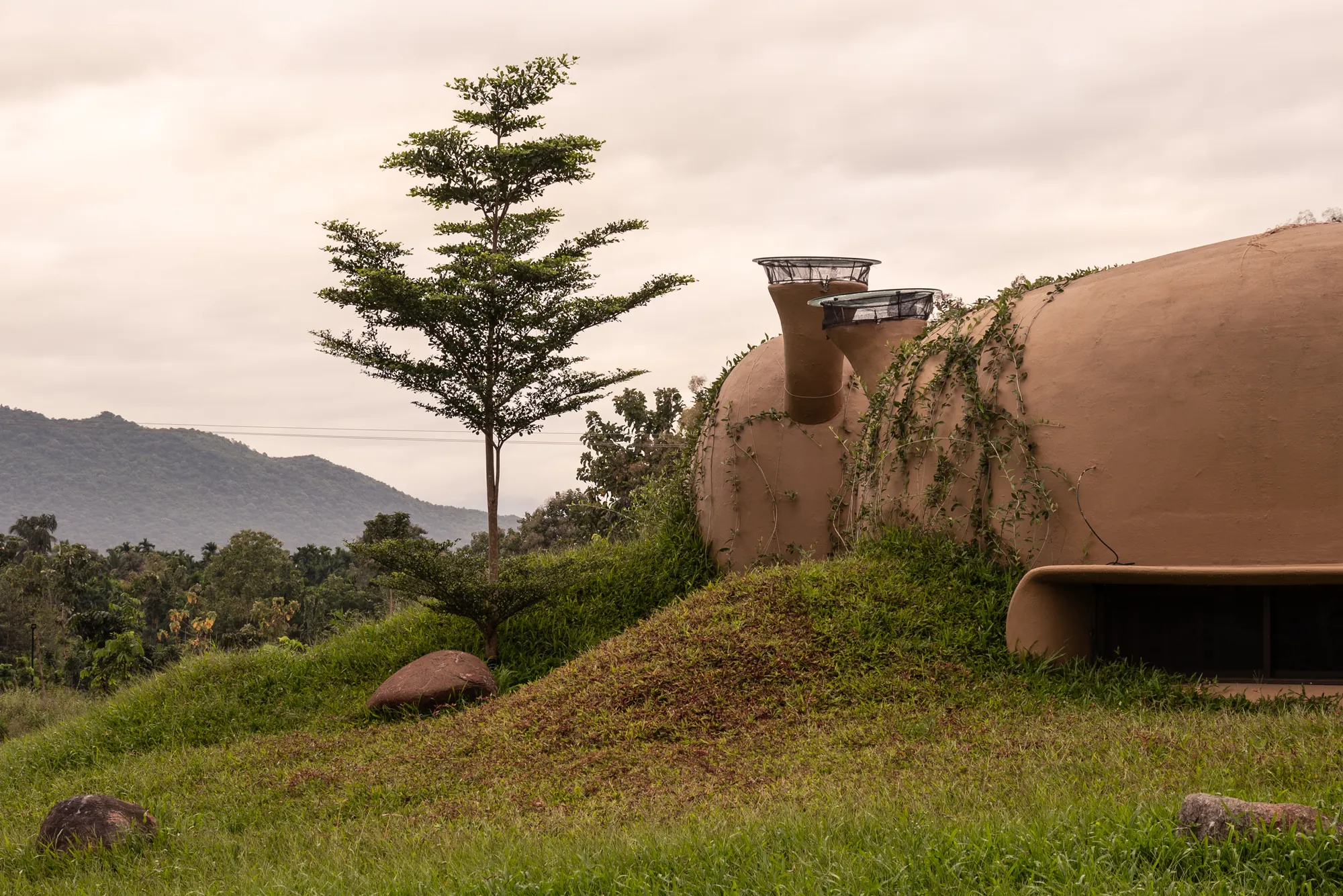 Folded into a 7½ ft landscaped mound, with the mountains beyond