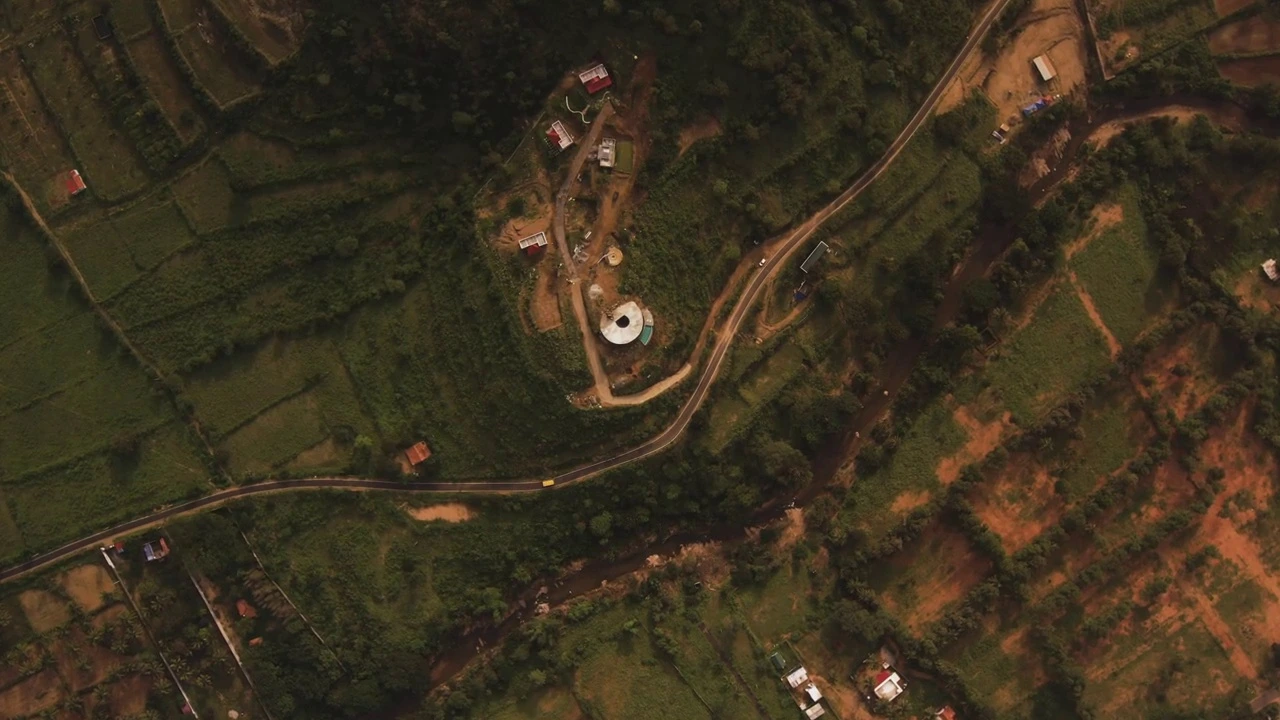 Aerial top-down perspective showing the circular quarry footprint and mountain road contour.